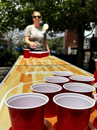 Woman playing beer pong at a SideQuest Event